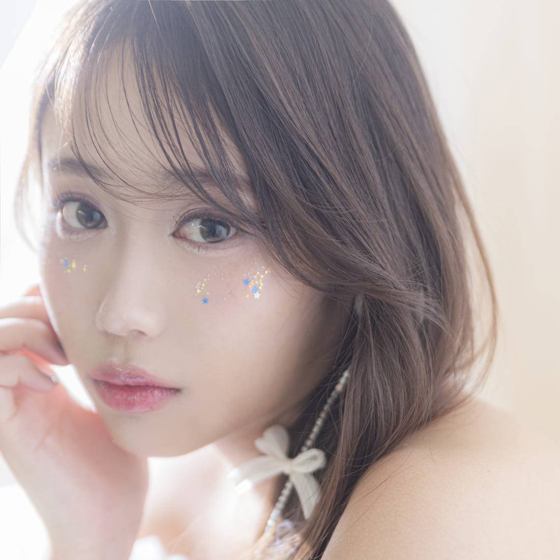 頬にラメが施されたこちらを見つめる女性