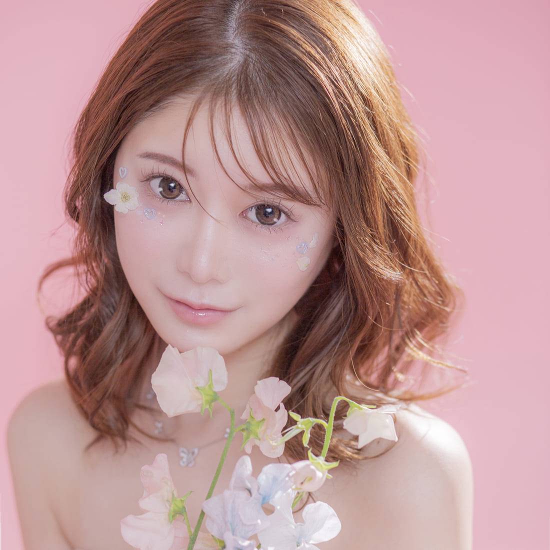 花を持ちこちらを見つめる女性